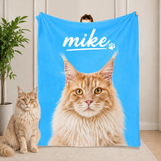 Young woman relaxing on a beige sofa wrapped in a yellow personalized pet blanket with a photorealistic orange Maine Coon cat print, fluffy Maine Coon cat lying nearby, cozy living room scene
