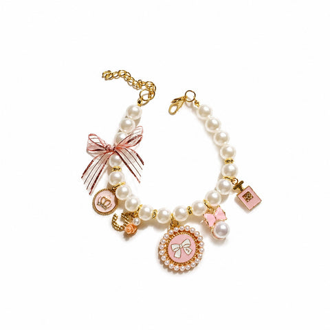 Luxury pearl cat collar with pink bow charms gold details and elegant designer necklace accessory for cats and small pets.